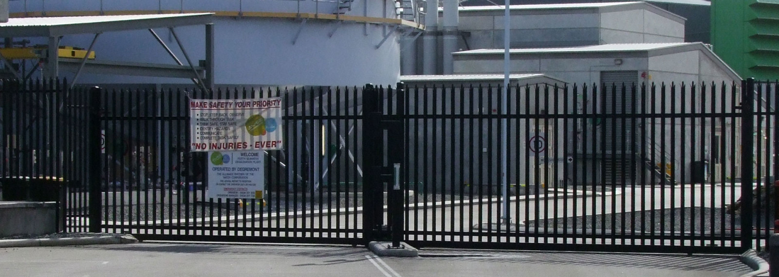 Black steel vehicle gates at an industrial entrance